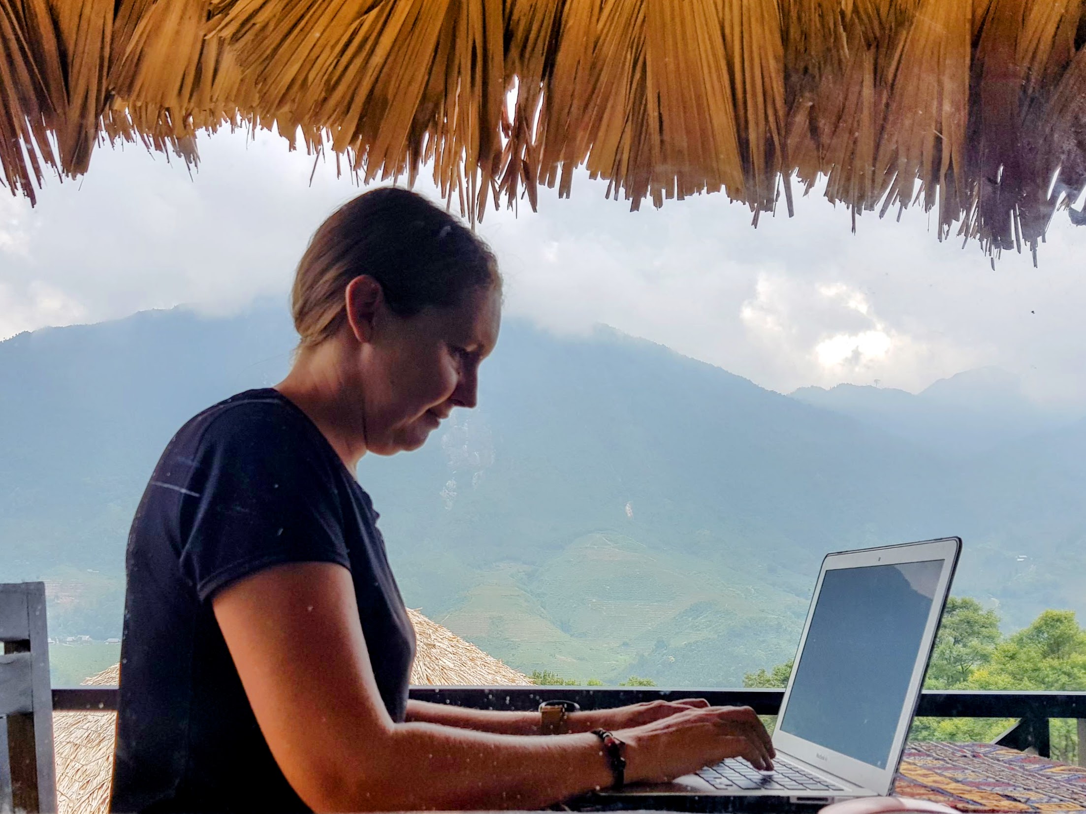 Melissa working on laptop outdoors with mountain view